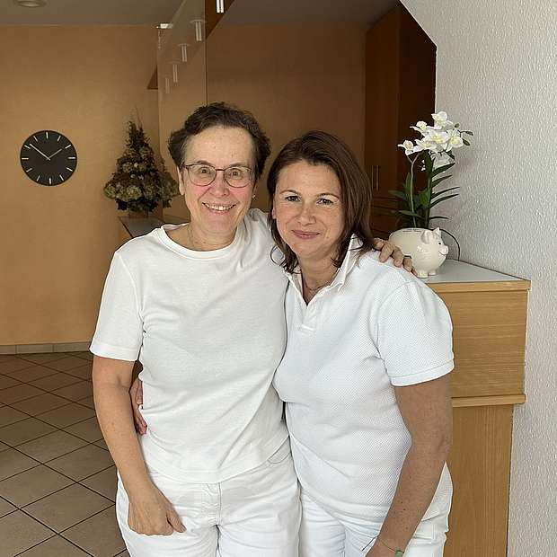Dr. Anne Hämmerlin-Schulz (l.) und Arzu Zocher (r.) Zwei Frauen liegen sich in den Armen und lachen in die Kamera.